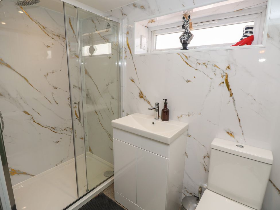 A bathroom with a shower, sink, and toilet at 8 Manor Villas Totland Bay