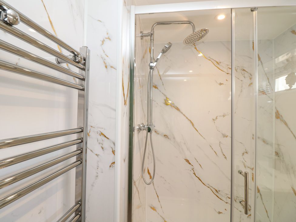 A bathroom with a shower and towel rail at 8 Manor Villas in Totland Bay