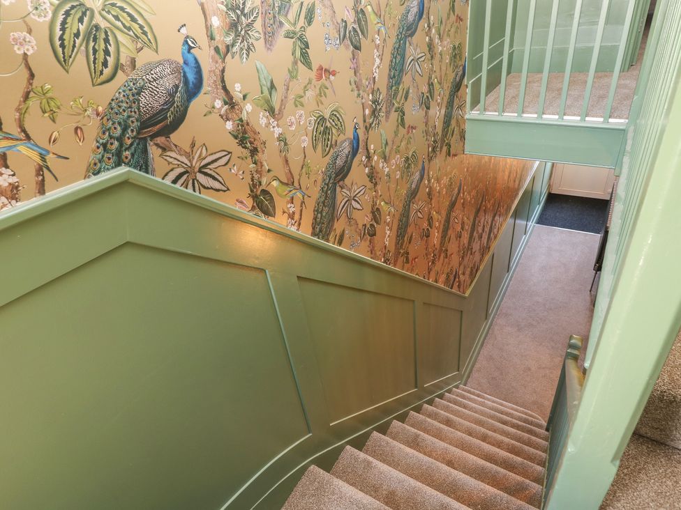 A staircase with decorative wallpaper in the hallway at 8 Manor Villas Totland Bay