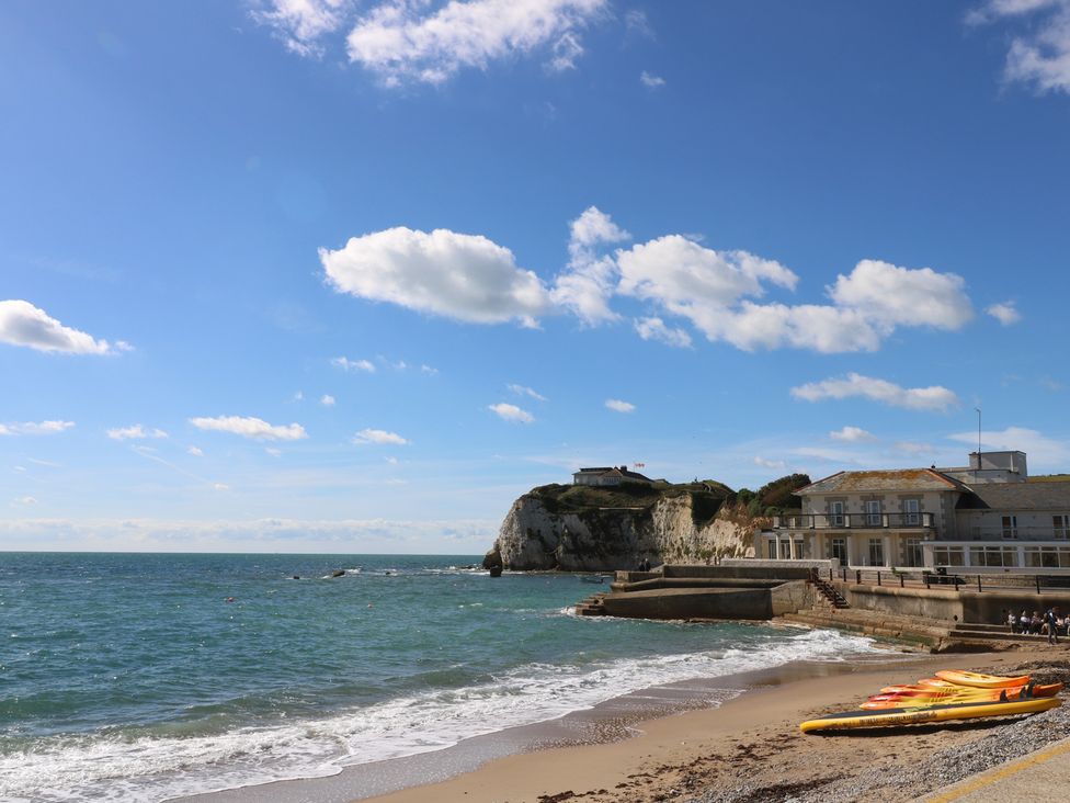 A beach with a cliff and kayaks at 8 Manor Villas in Totland Bay
