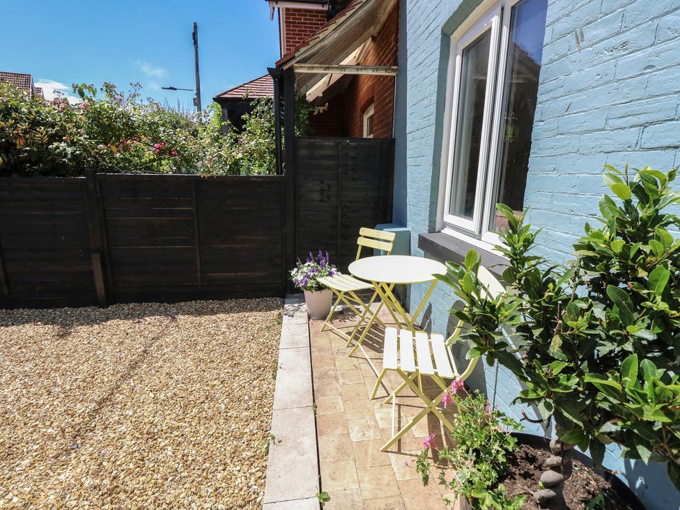 An outdoor area with a table and chairs at 8 Manor Villas Totland Bay