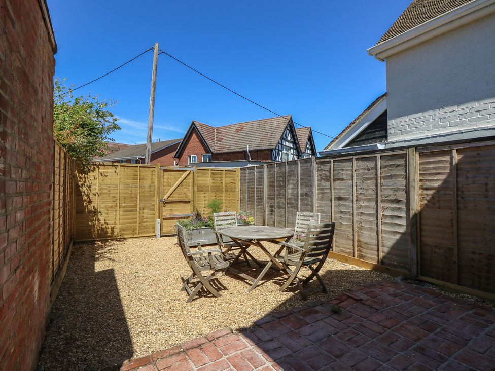A garden with a table and chairs at 8 Manor Villas in Totland Bay