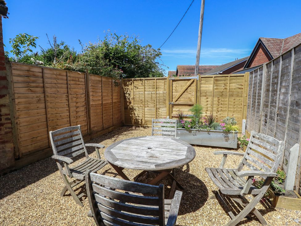 A garden with seating and a table at 8 Manor Villas Totland Bay
