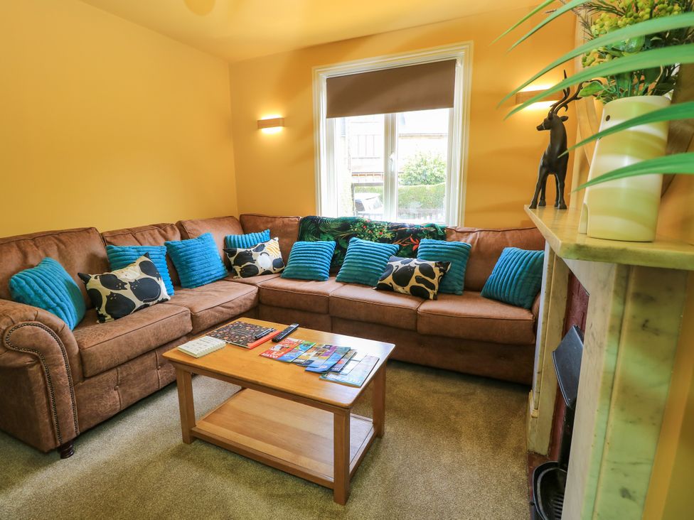 A living room with a brown sofa and a coffee table at 8 Manor Villas in Totland Bay