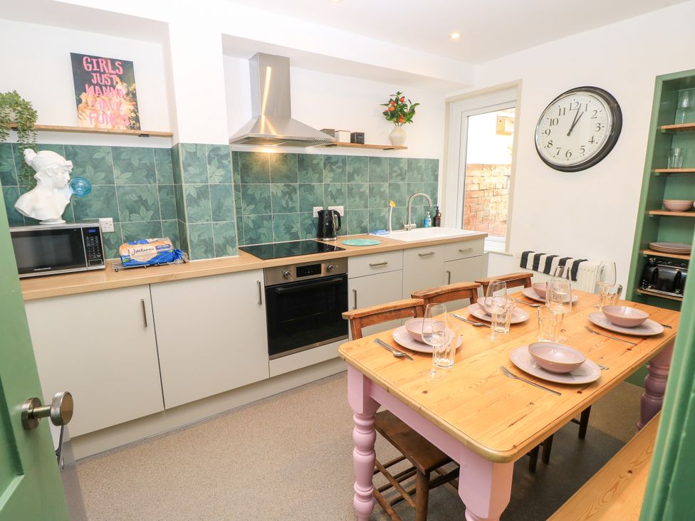 A kitchen with table and chairs at 8 Manor Villas Totland Bay