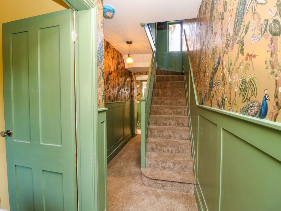 A hallway with a staircase and decorative wall at 8 Manor Villas in Totland Bay