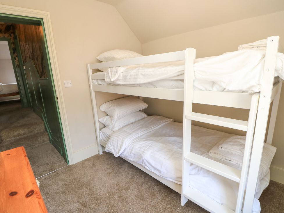 A bedroom with a bunk bed and pillows at 8 Manor Villas Totland Bay