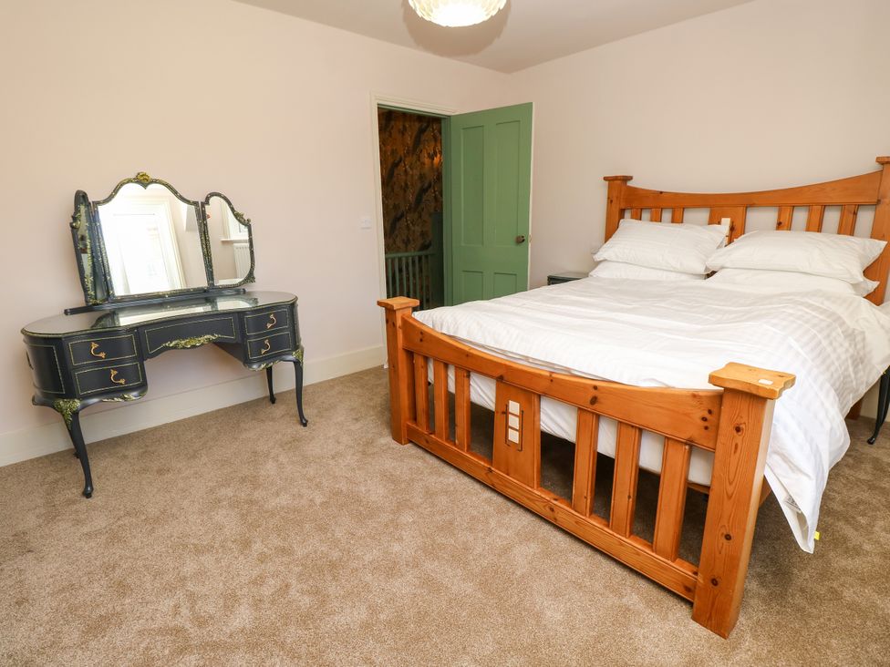 A bedroom with a bed and a dresser at 8 Manor Villas Totland Bay
