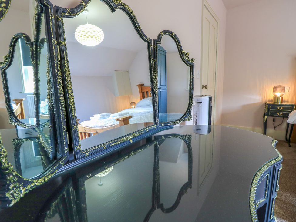 A vanity mirror and table in a bedroom at 8 Manor Villas Totland Bay