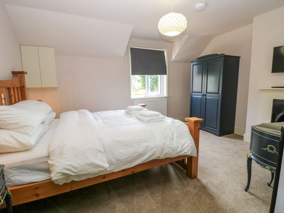 A bedroom with a bed and wardrobe at 8 Manor Villas in Totland Bay