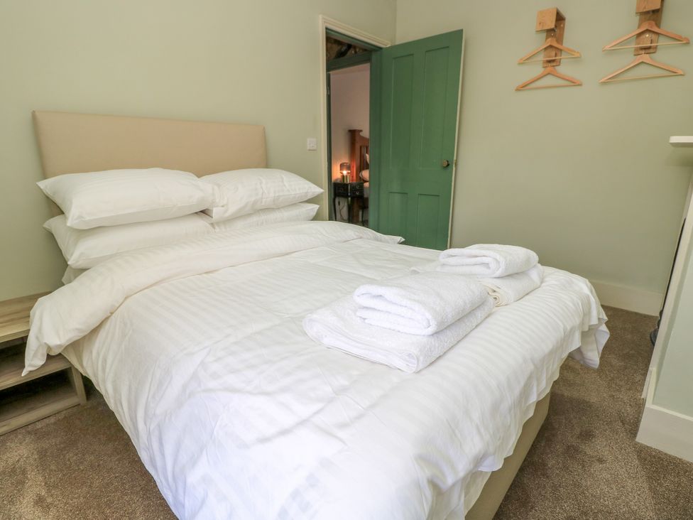 A bedroom with a bed and towels at 8 Manor Villas in Totland Bay