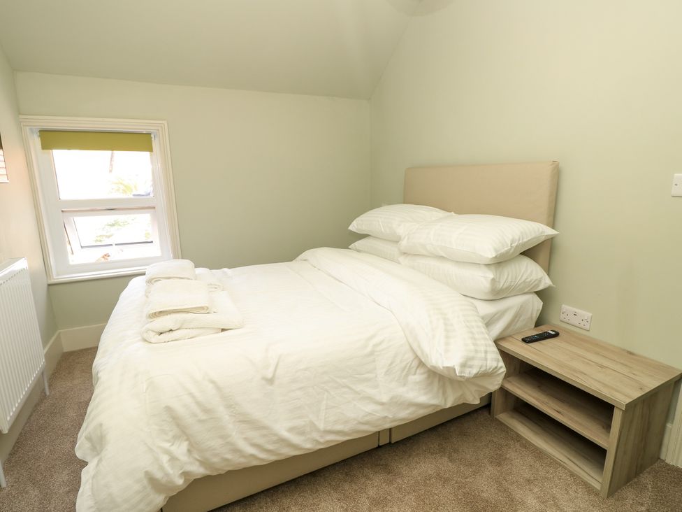 A bedroom with a bed and bedside table at 8 Manor Villas Totland Bay