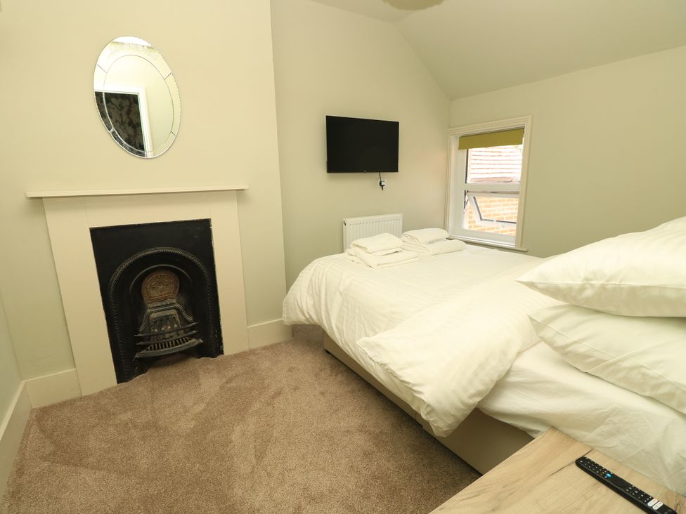 A bedroom with a bed and television at 8 Manor Villas Totland Bay