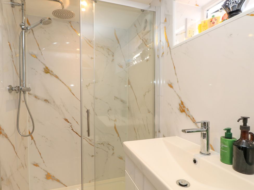 A bathroom with a shower enclosure and sink at 8 Manor Villas in Totland Bay