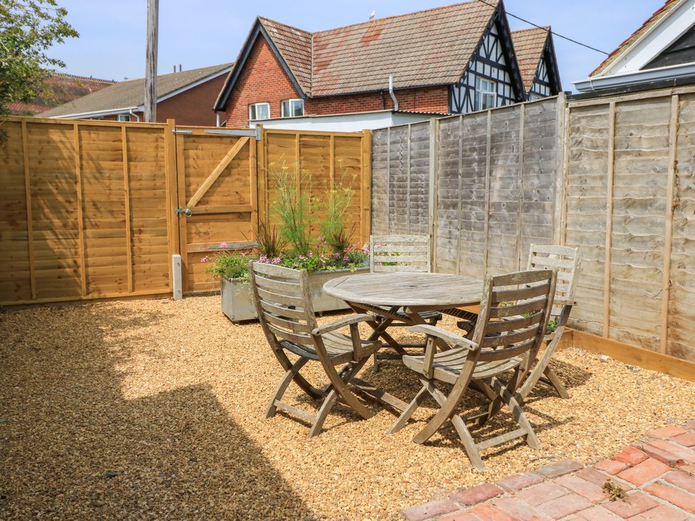 A garden with a table and chairs at 8 Manor Villas in Totland Bay