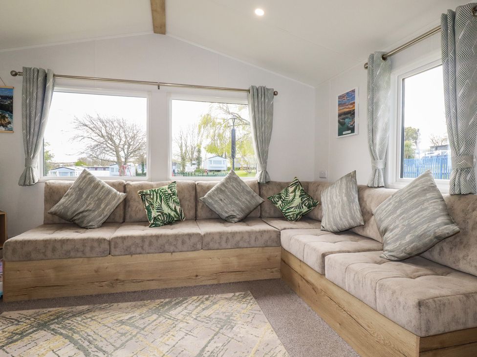 A living room with a sofa and cushions at Shamrocks Cove Caravan