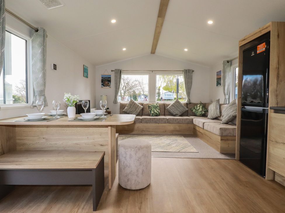 A living room with a dining area and couch at Shamrocks Cove Caravan