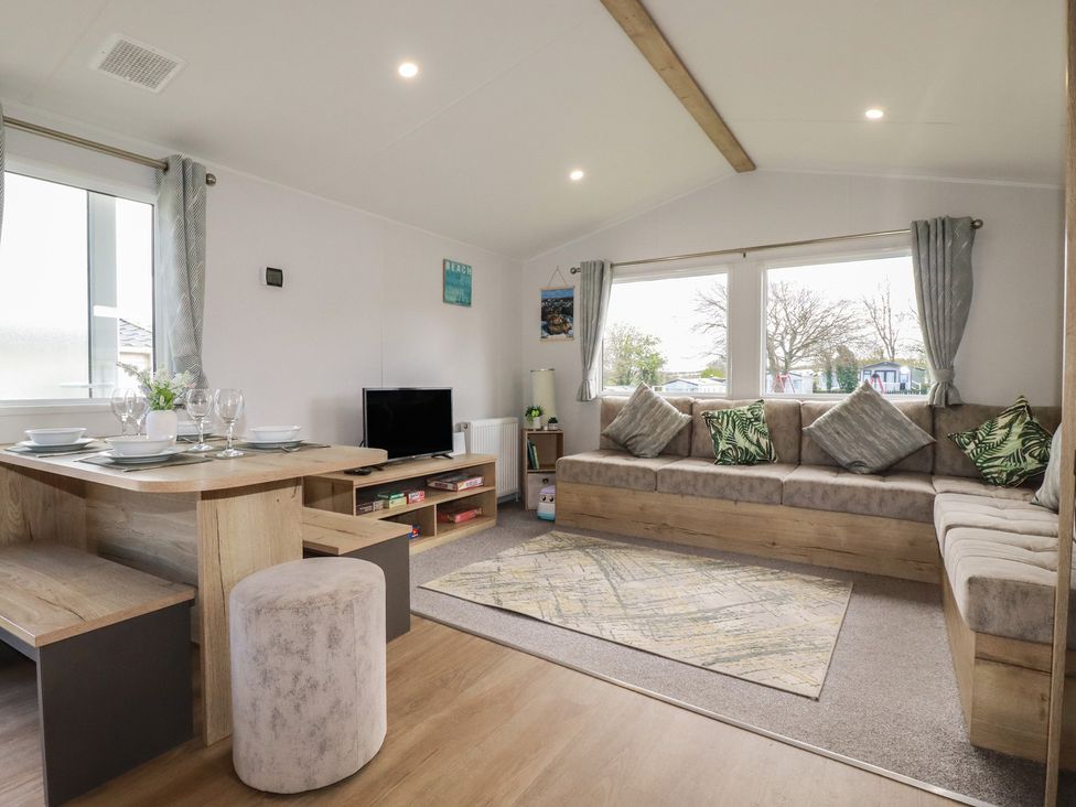 A living room with a dining table and sofa at Shamrocks Cove Caravan