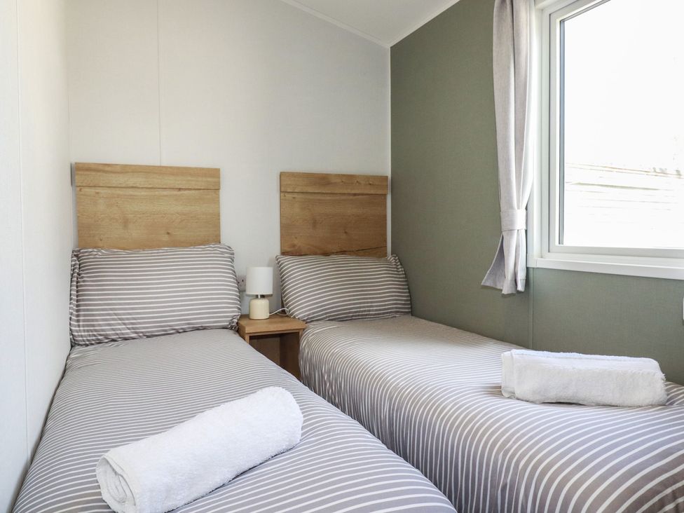 A bedroom with two single beds at Shamrocks Cove Caravan