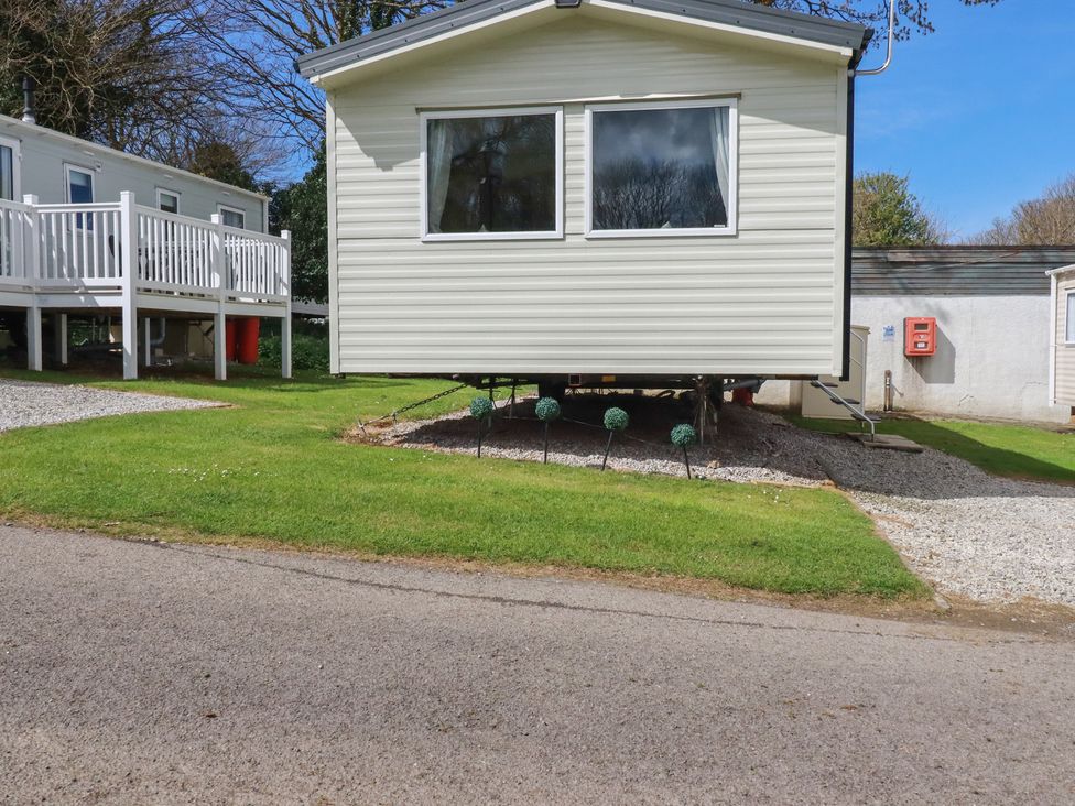 A caravan with a deck and steps at Shamrocks Cove Caravan