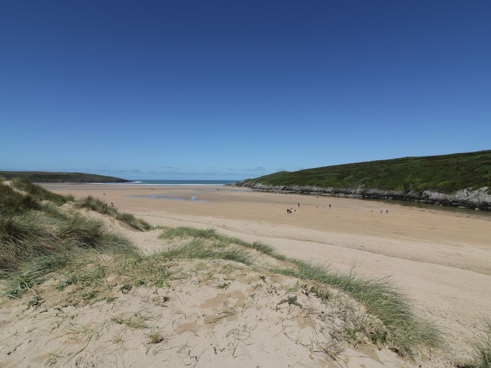 A beach with sand and people at Shamrocks Cove Caravan in 