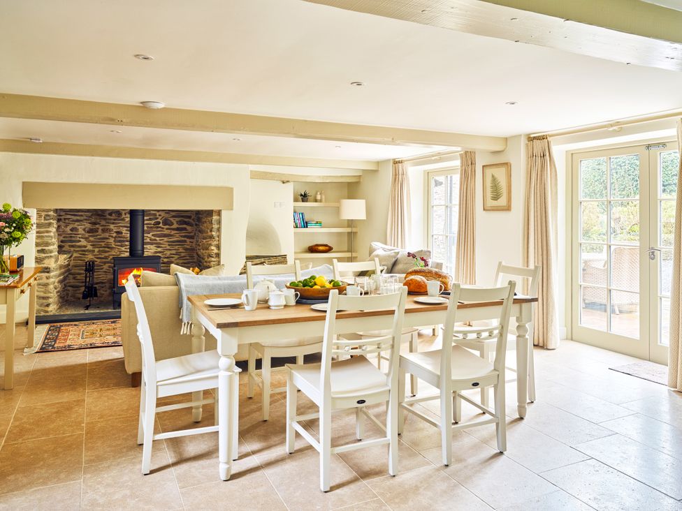 A dining room with a table and chairs at Gitcombe Coach House in Totnes
