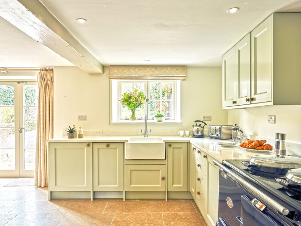 A kitchen with a sink and cabinets at Gitcombe Coach House in Totnes