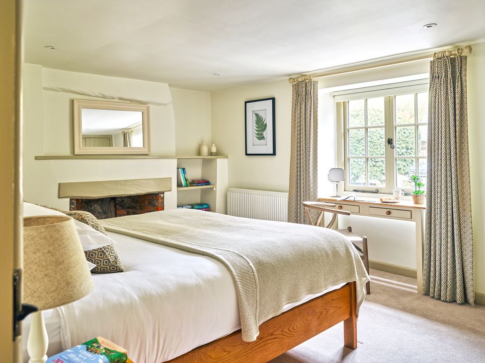 A bedroom with a bed and desk in Gitcombe Coach House, Totnes