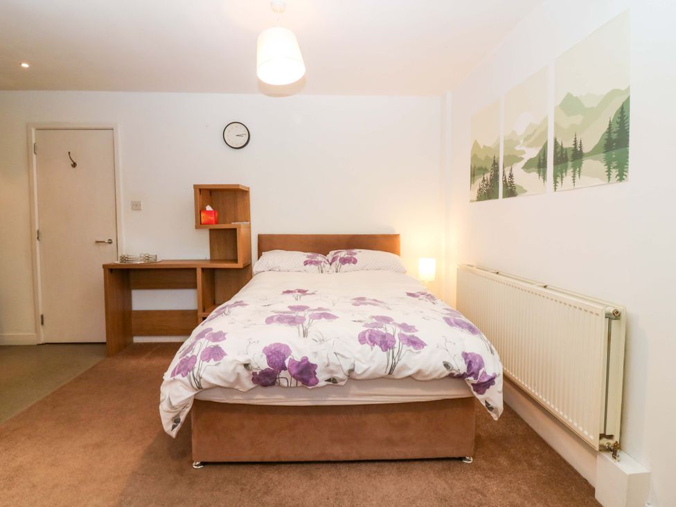 A bedroom with a bed and desk in Apartment 1 Dyce