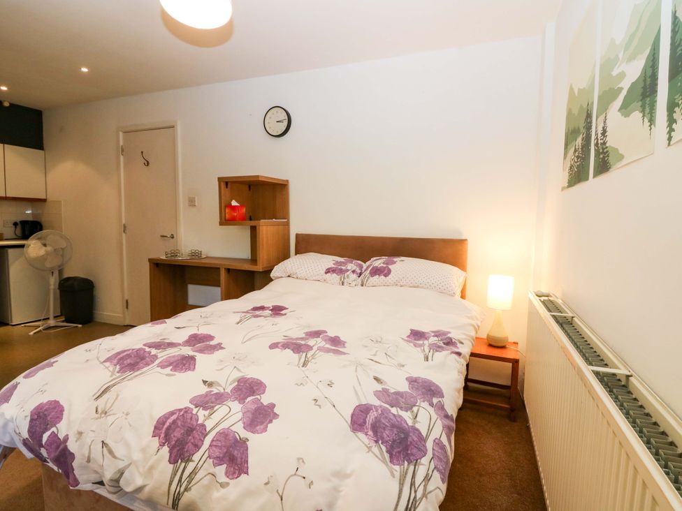 A bedroom with a bed and a fan at Apartment 1 in Dyce