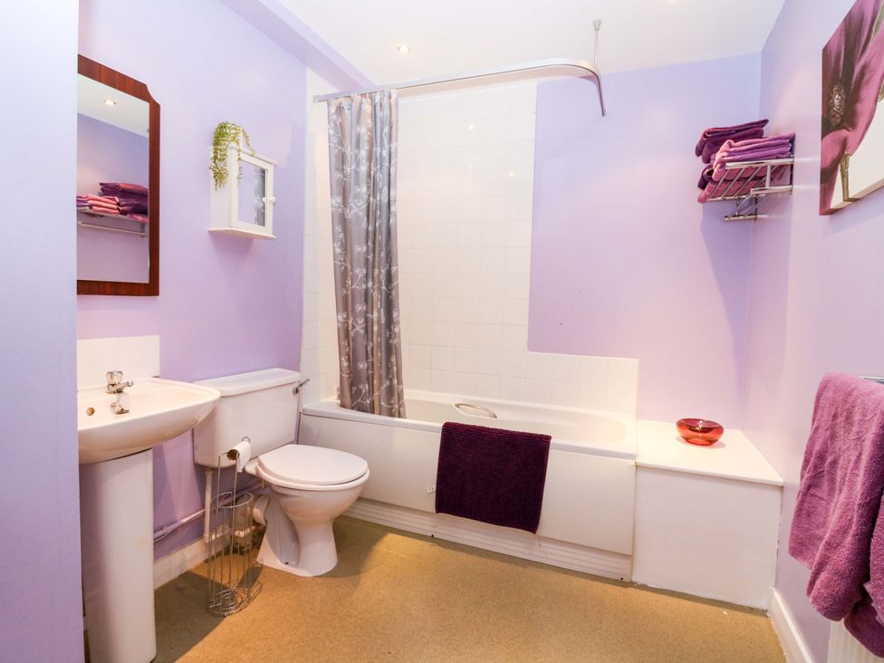 A bathroom with a bathtub and sink at Apartment 1 in Dyce