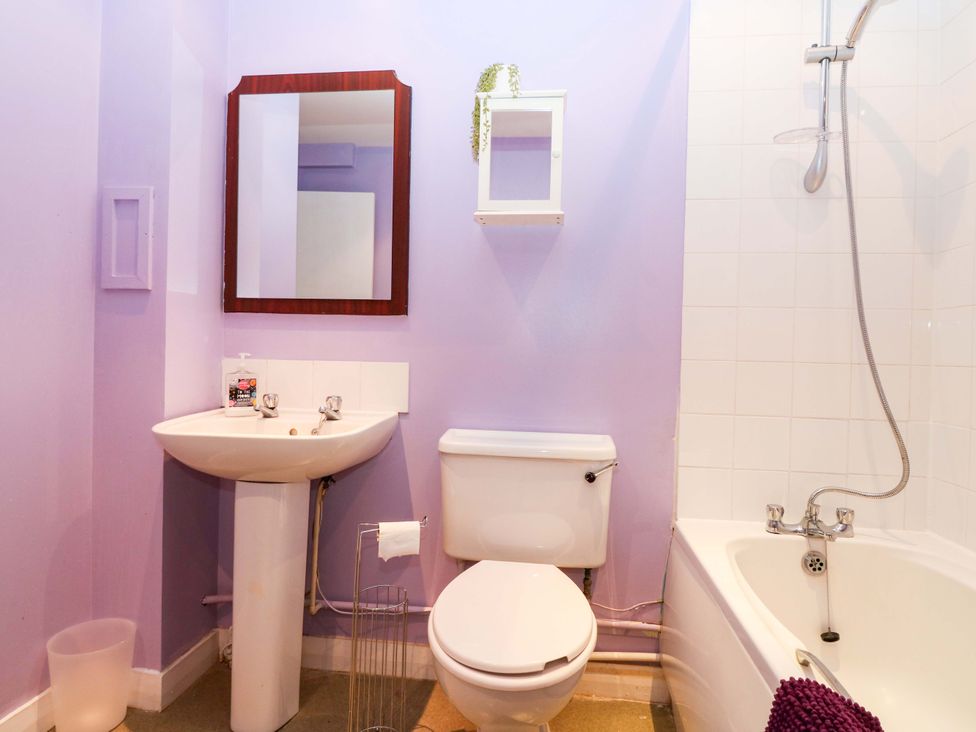 A bathroom with a sink, toilet, and bathtub at Apartment 1 in Dyce