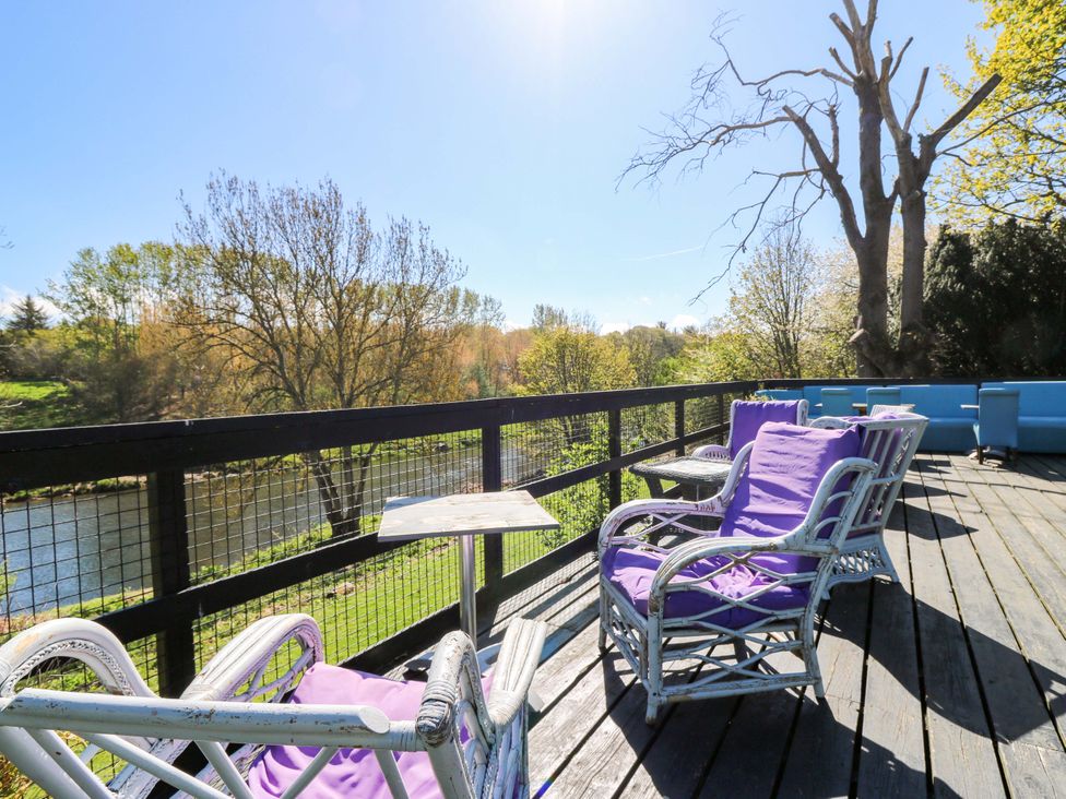 An outdoor seating area with chairs and a table overlooking a river at Apartment 1 in Dyce