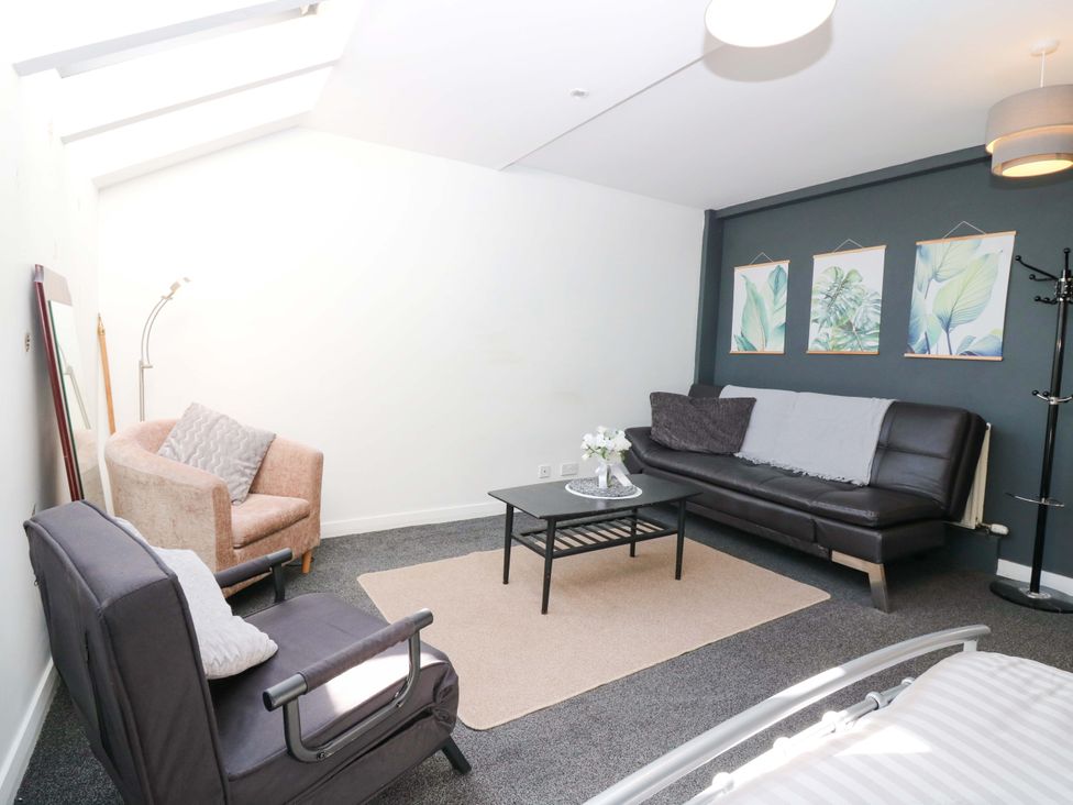 A living room with a sofa and armchair at Apartment 2 in Dyce