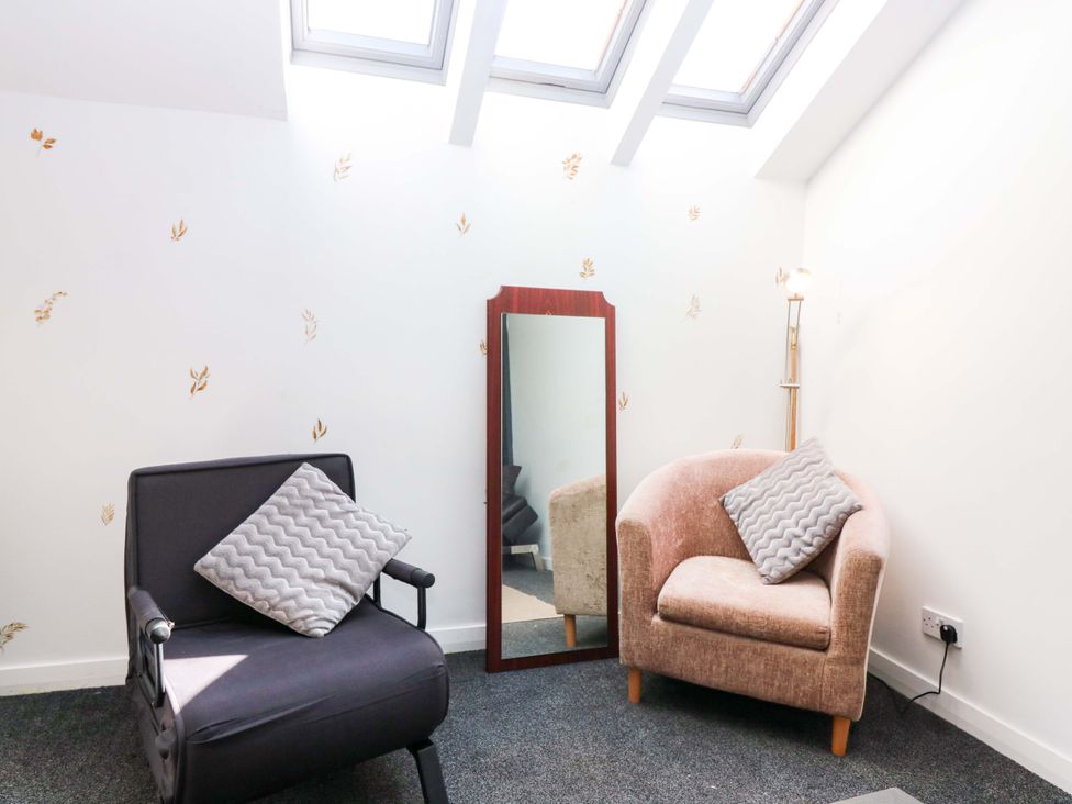 A sitting room with two chairs and a mirror at Apartment 2 in Dyce