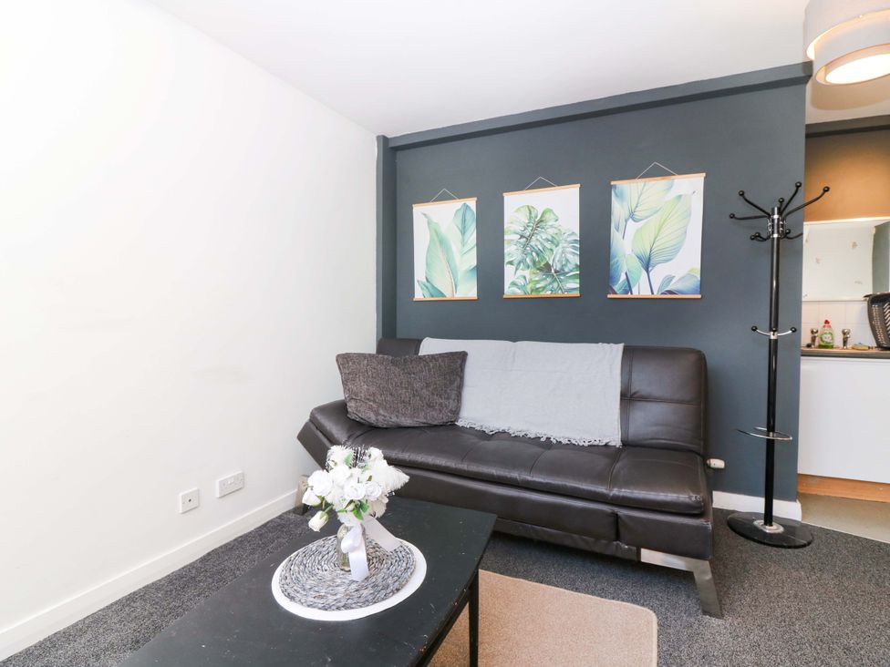A living room with a sofa and wall art at Apartment 2 in Dyce