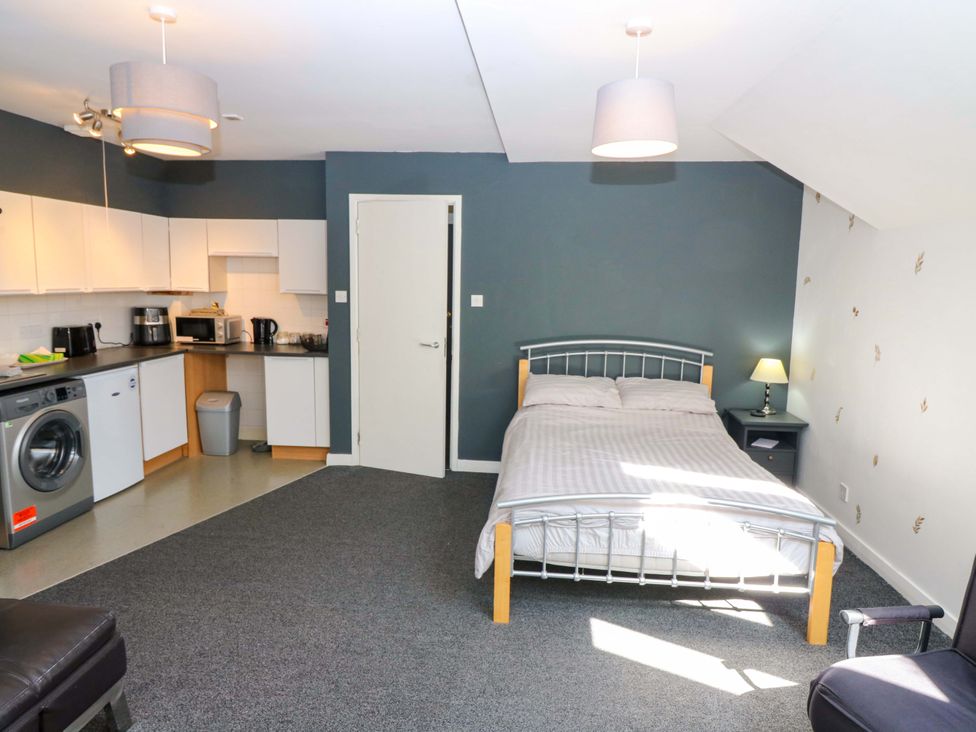 A studio apartment with a kitchen area and sleeping area at Apartment 2 in Dyce