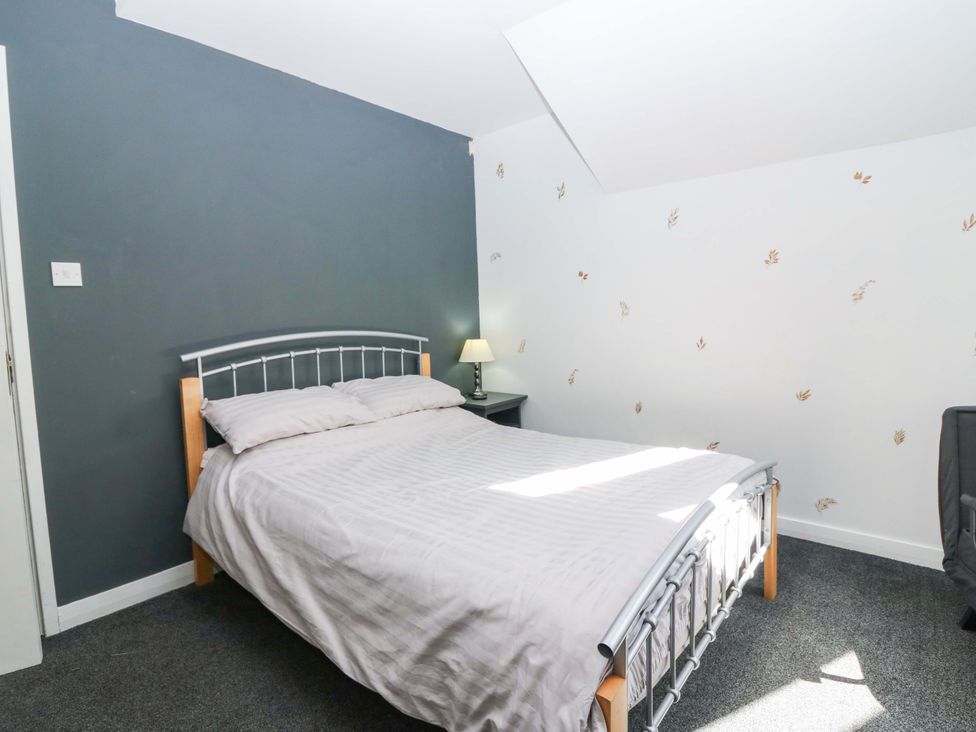 A bedroom with a bed, lamp and nightstand at Apartment 2 Dyce