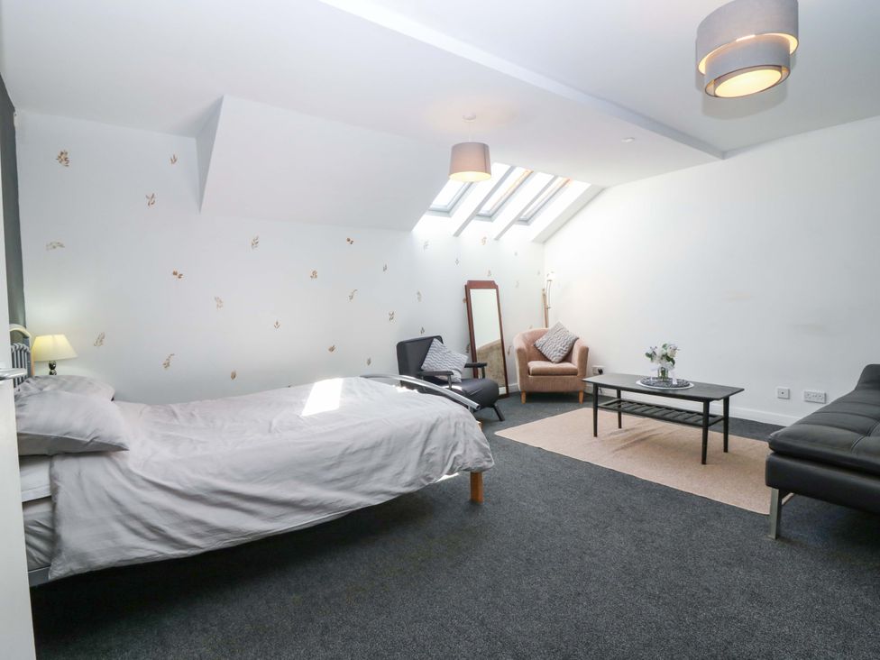 A bedroom with a bed and a coffee table at Apartment 2 in Dyce