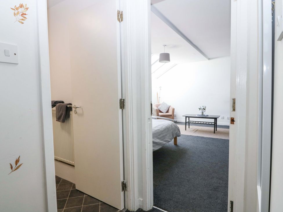 A bedroom with a bed and a chair at Apartment 2 in Dyce