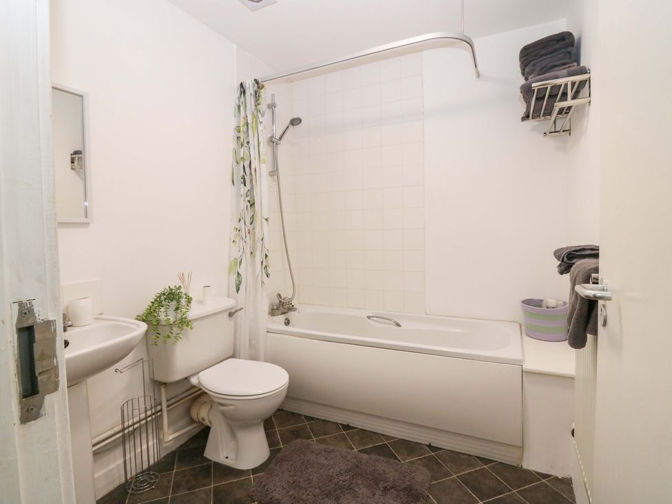 A bathroom with a bathtub, toilet, and sink at Apartment 2 in Dyce