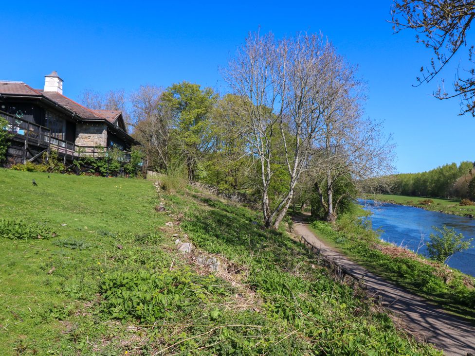 A house by a river with a path and trees in Dyce