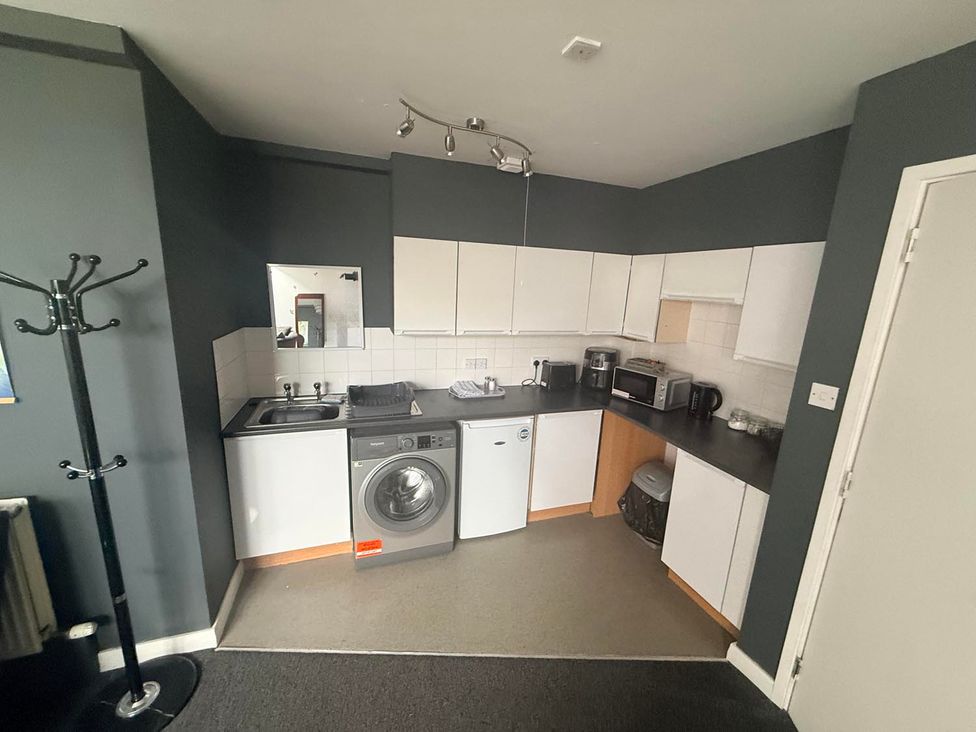 A kitchen with appliances and fixtures at Apartment 3 in Dyce