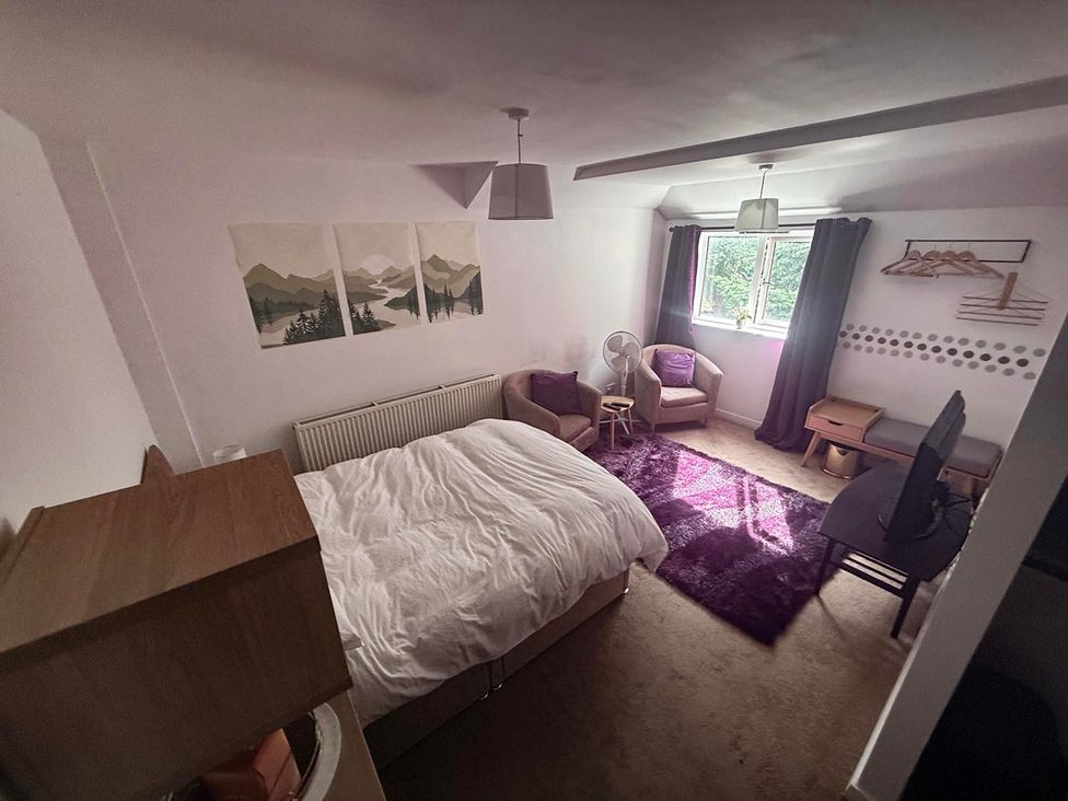A bedroom with a bed and chair at Apartment 3 in Dyce