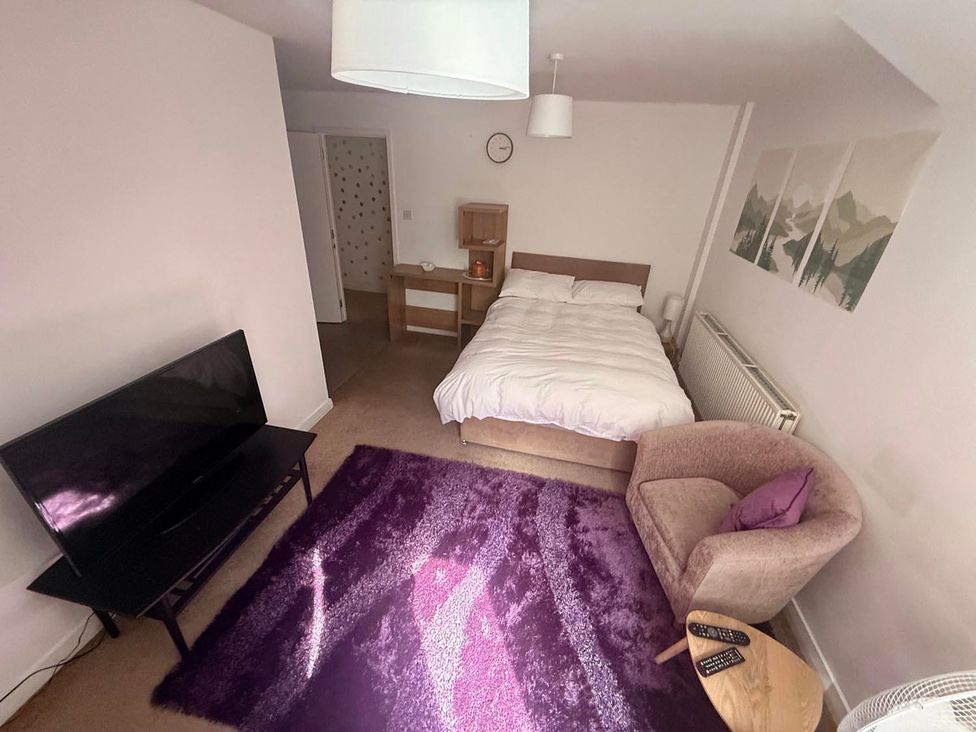 A bedroom with a bed and TV at Apartment 3 in Dyce