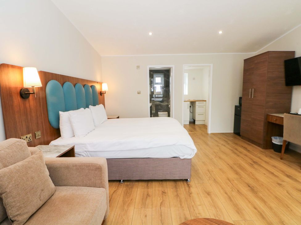 A bedroom with a bed and sofa at 1 bed no. 3 Chorley