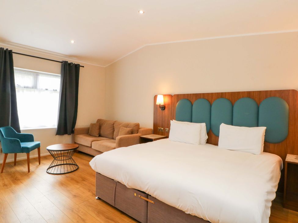 A bedroom with a bed, sofa, and chair at 1 bed no. 3 Chorley