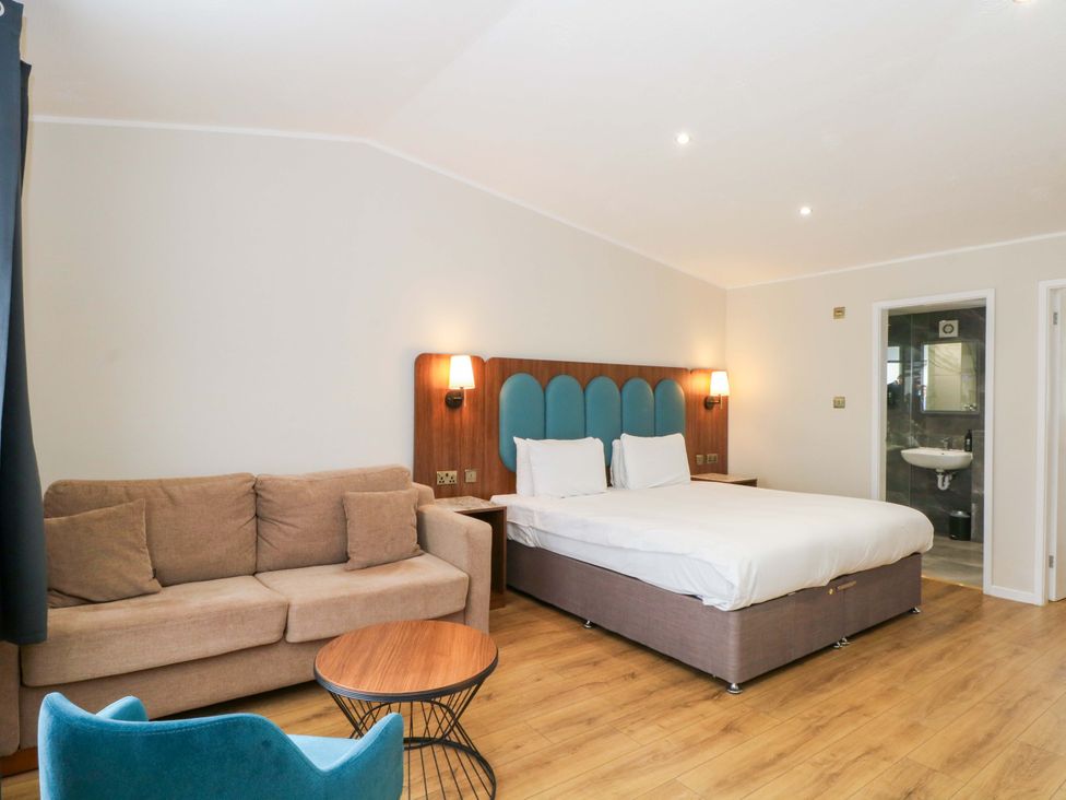 A bedroom with a bed and sofa at 1 bed no.5 Chorley