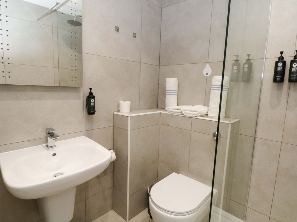 A bathroom with a sink, toilet, shower and towels at 2 bed no. 3 Chorley