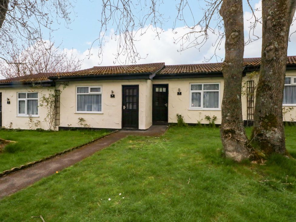 A property with doors and windows surrounded by grass and trees at 2 bed no. 3 in Chorley